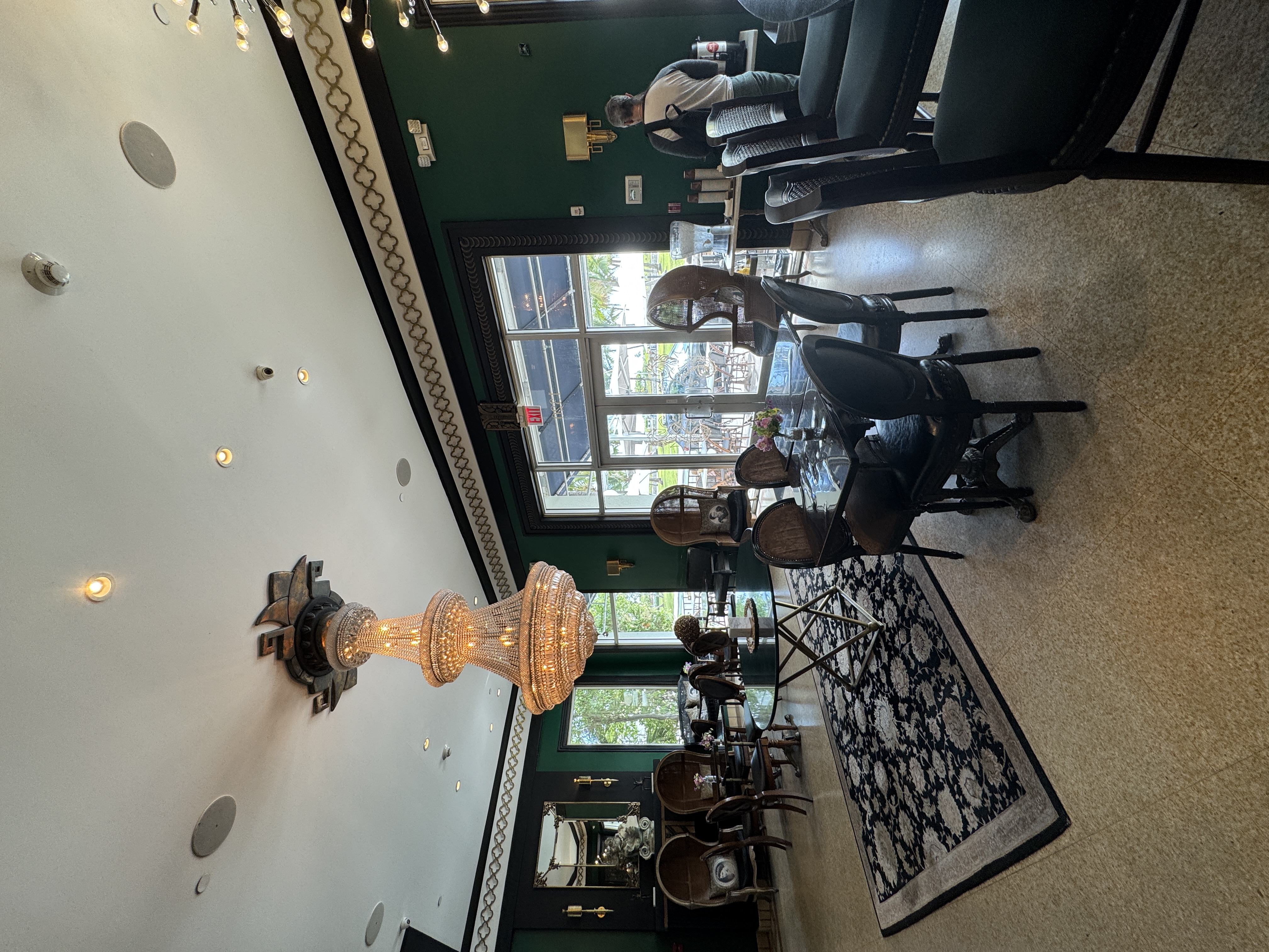 A luxurious lobby with a chandelier, seating area, and large windows.